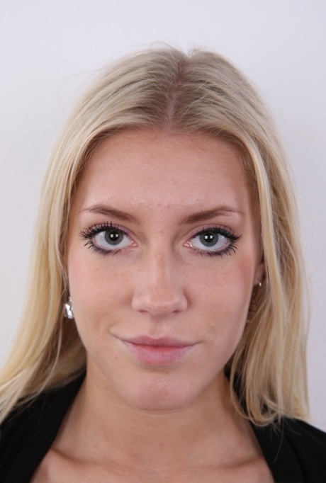 Blonde amateur Klara stands fully clothed and then totally naked afore a wall