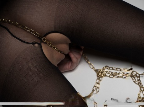 Blonde teen Lizzy B models by herself in a crotchless bodystocking