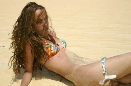 Latina teen Miranda Mirelli models in a bikini atop a sand dune