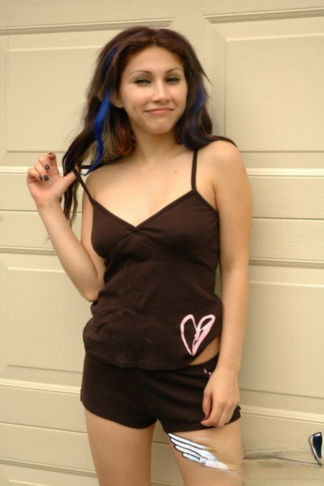 Cute teen Angel teases her long hair while exposing herself in a yard