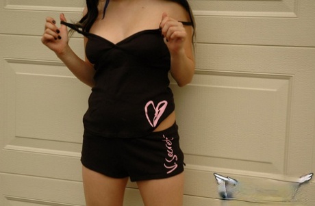 Cute teen Angel teases her long hair while exposing herself in a yard