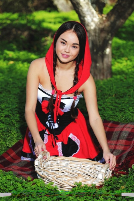 Cute little Li Moon in pigtails on her knees outdoors to show her bald pussy