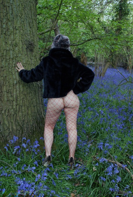 Mature lady removes her winter coat to show her big naturals in mesh pantyhose