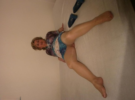 Mature woman Caro looses a breast on a bed in sheer pantyhose