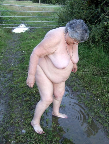 Fat nan Grandma Libby steps into a puddle before covering herself in mud