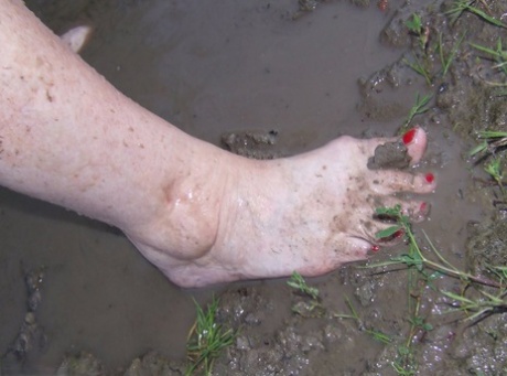 Fat nan Grandma Libby steps into a puddle before covering herself in mud