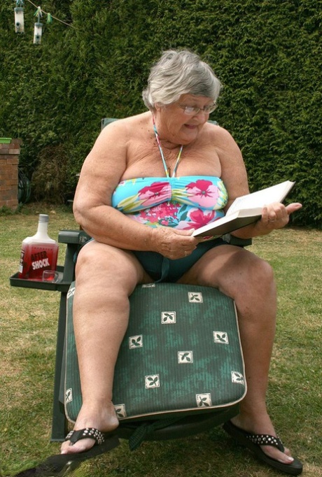Naughty amateur granny Libby inserting a bottle in her fat pussy in the garden