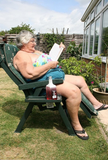 Naughty amateur granny Libby inserting a bottle in her fat pussy in the garden
