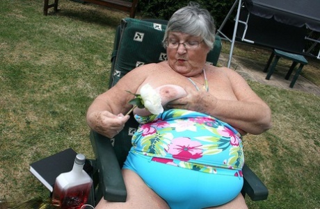 Naughty amateur granny Libby inserting a bottle in her fat pussy in the garden