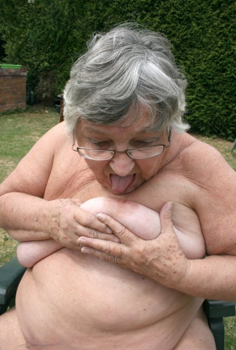 Naughty amateur granny Libby inserting a bottle in her fat pussy in the garden