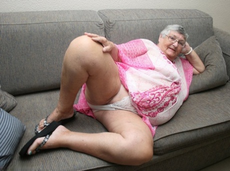 Horny Grandma Libby strips and spreads her old shaved pussy on the sofa