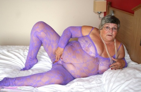 British fatty Grandma Libby masturbates on a bed in a crotchless bodystocking