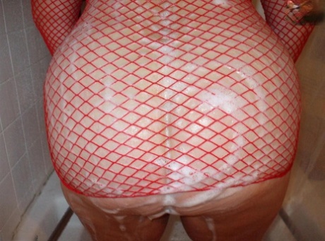 Older amateur Busty Bliss soaps up her boobs in a mesh dress