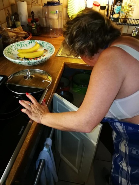 Old housewife Caro takes off her underwear in kitchen apron and stockings