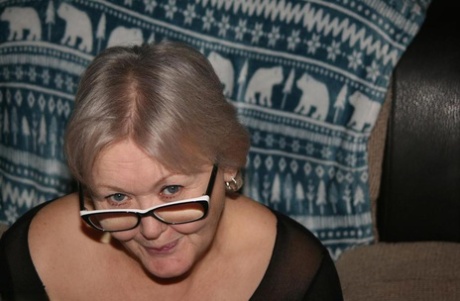 Old woman takes off her glasses before exposing her big ass and bald pussy