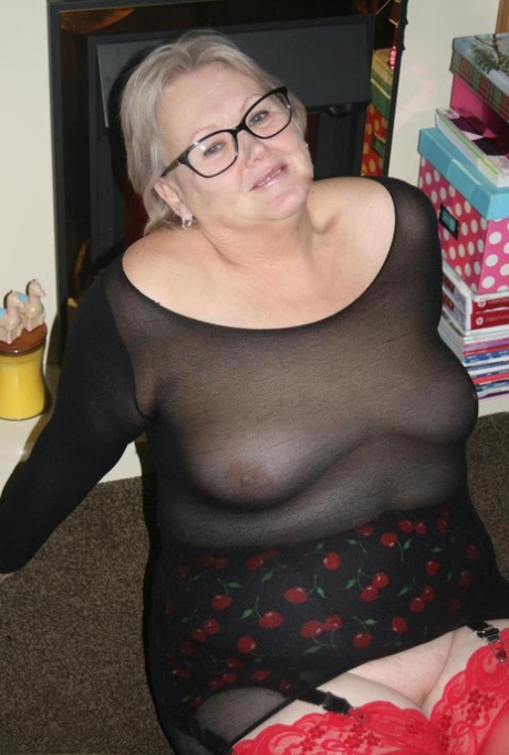 Old woman takes off her glasses before exposing her big ass and bald pussy