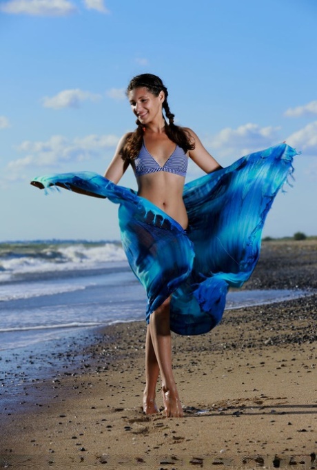 Teen girl Rosella plays with pigtails before taking off her bikini on a beach