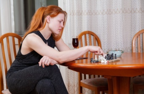 Pale redhead Jana Bay undresses after a glass of red wine