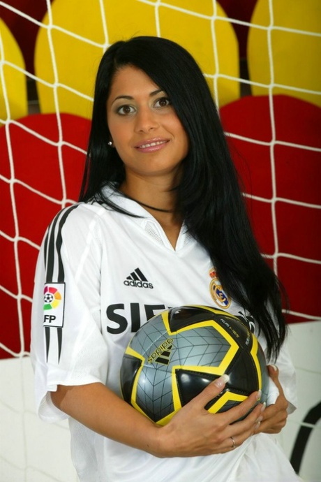 Soccer tender with long black hair strips to knee socks and cleats in goal