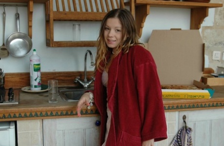 Charming young girl teases in lingerie after a glass of OJ for breakfast