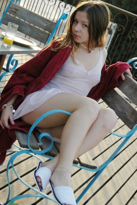 Charming young girl teases in lingerie after a glass of OJ for breakfast