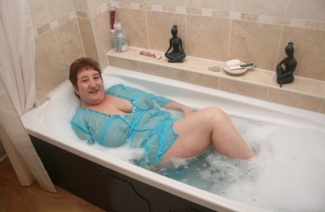 Redhead nan Kinky Carol shows her big ass and snatch in a bathtub