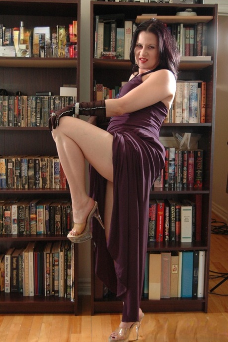 Amateur model Mina Gorey strips naked in gloves and heels afore a bookcase