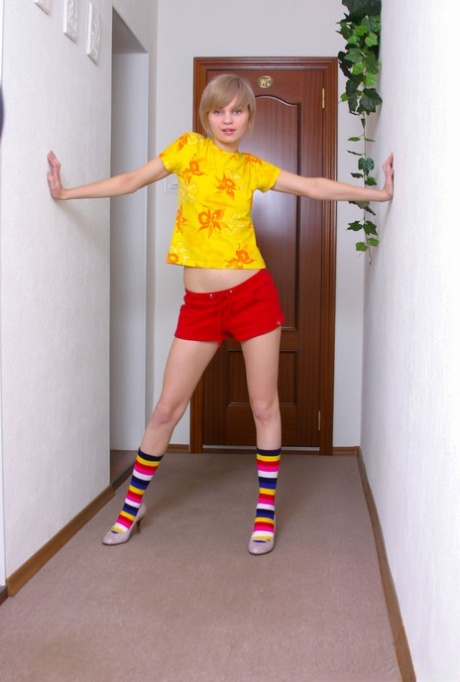 Cute 18 year old Lily L gets naked in multi coloured socks and heels