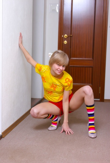 Cute 18 year old Lily L gets naked in multi coloured socks and heels