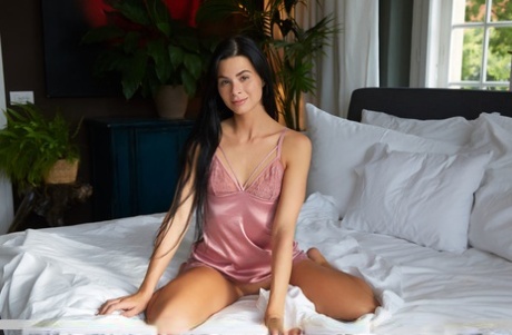 Dark haired teen Jenny Doll doffs satin lingerie before confident nude poses