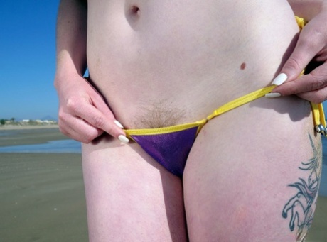 Solo girl Carly Rae shows pubic hairs while modelling a bikini at low tide