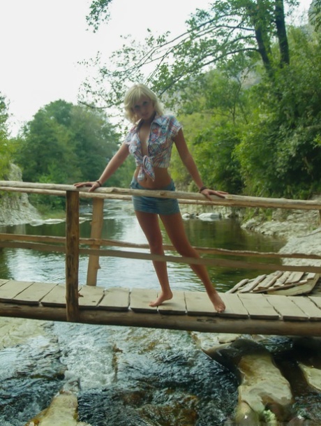 18-year-old blonde Nellie Y gets bare naked on a footbridge across a stream