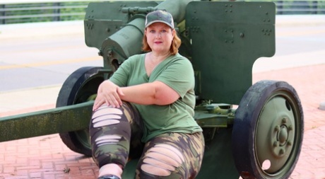 Obese amateur Goddess Pear models for a SFW shoot on an artillery gun in camo