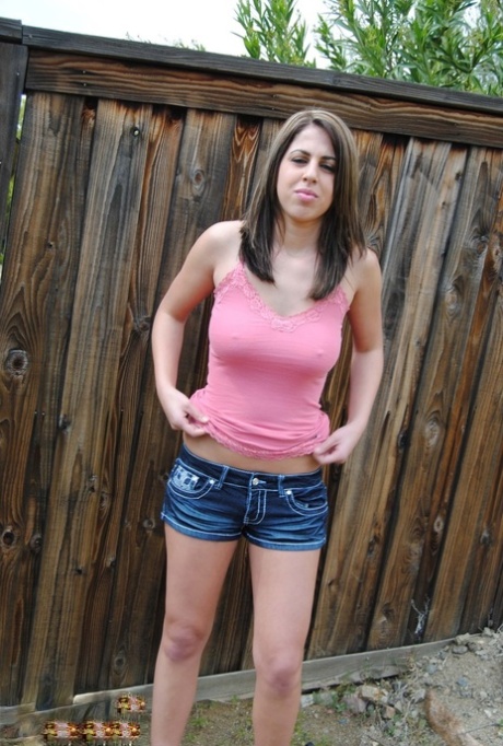 Brunette teen Heavenly Smut pulls down her shorts in a backyard