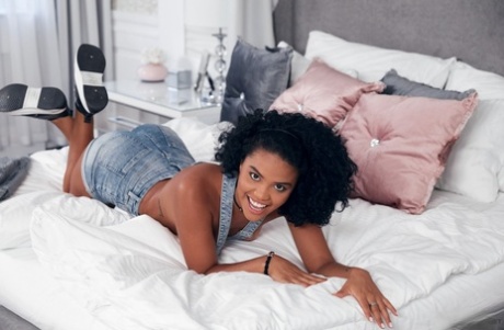Sexy ebony teen Selva Lapiedra fingers her pussy on a bed in running shoes
