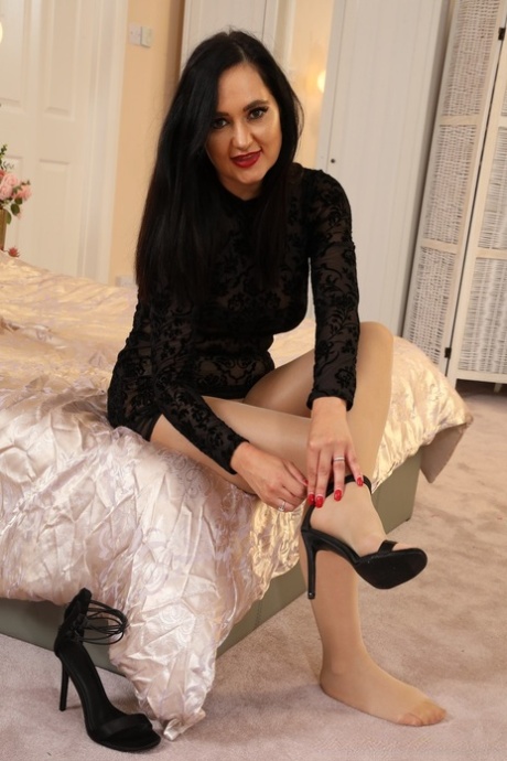 Sexy brunette Bonnie uncovers her firm breasts in gloss pantyhose