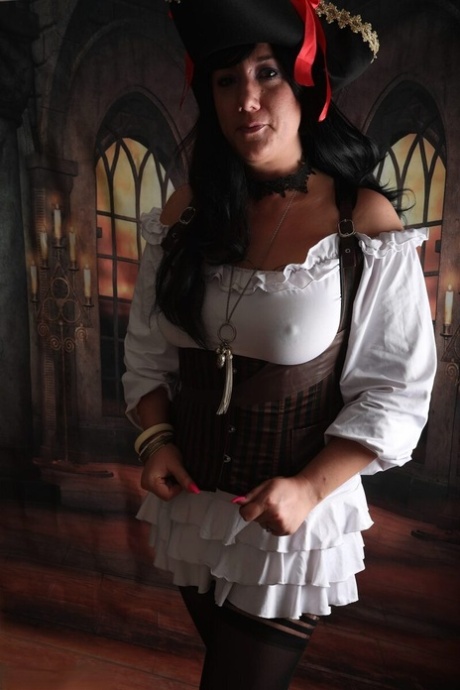 Dark-haired woman Sara Banks sports handcuffs while outfitted in pirate attire