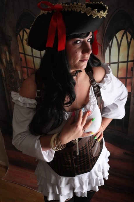 Dark-haired woman Sara Banks sports handcuffs while outfitted in pirate attire
