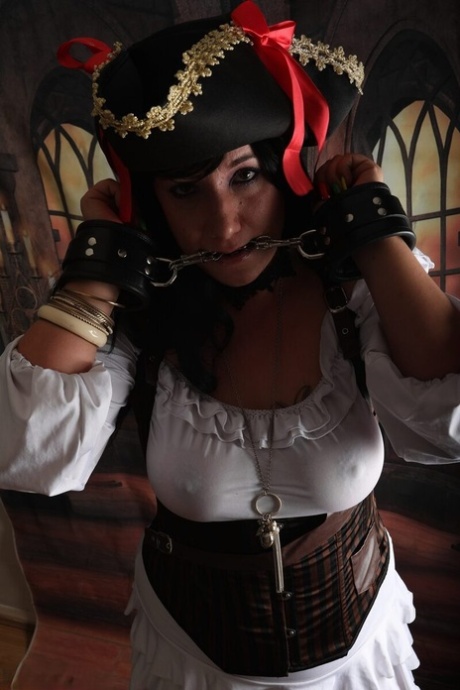 Dark-haired woman Sara Banks sports handcuffs while outfitted in pirate attire