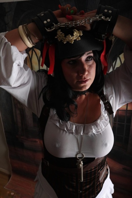 Dark-haired woman Sara Banks sports handcuffs while outfitted in pirate attire