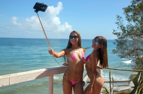Lola Banny and her teen gf strip off string bikinis on oceanside patio