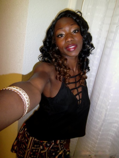 Sassy ebony sweetie stripping down and exposing her ample bosoms