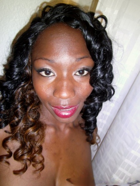 Sassy ebony sweetie stripping down and exposing her ample bosoms