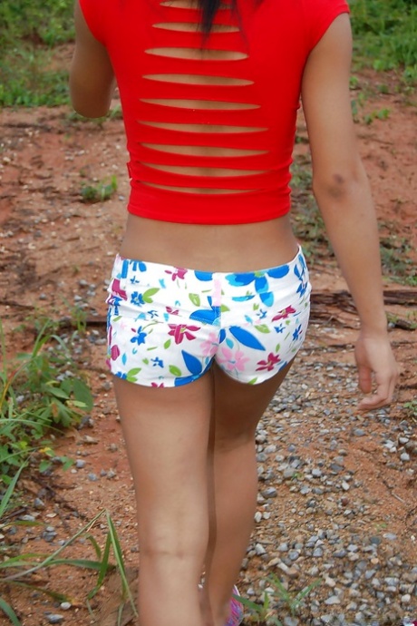 Busty young Asian ladyboy getting naked and spreading outdoors
