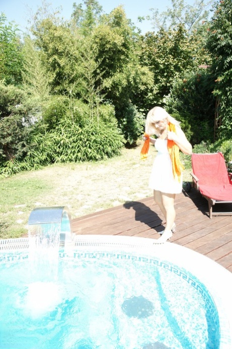 Arousing European mature Yazmine strips and masturbates poolside
