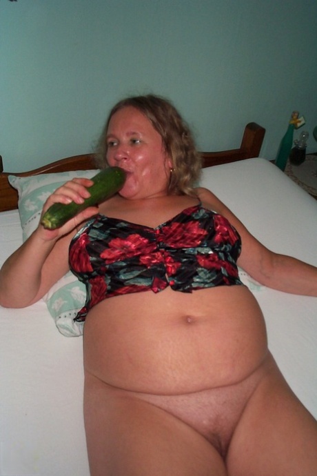 Mature fatty Diny rubs her beaver with a huge cucumber in the chair