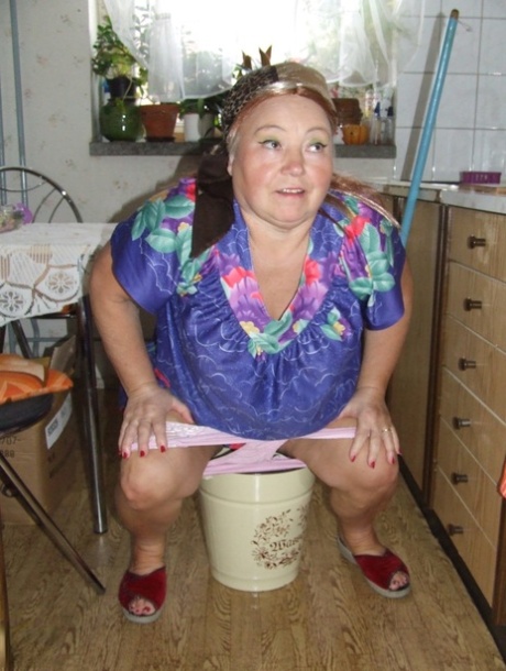 Fat granny Regina strips her clothes and poses while cleaning the kitchen
