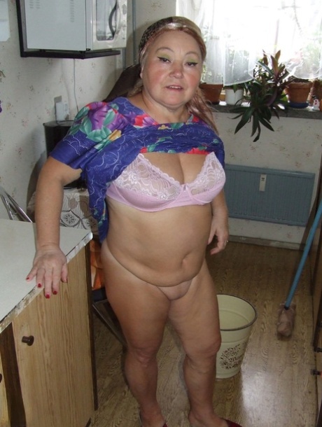 Fat granny Regina strips her clothes and poses while cleaning the kitchen