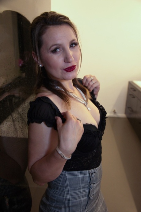 Sexy MILF Olga Love exposes her juggs and round ass before touching her twat