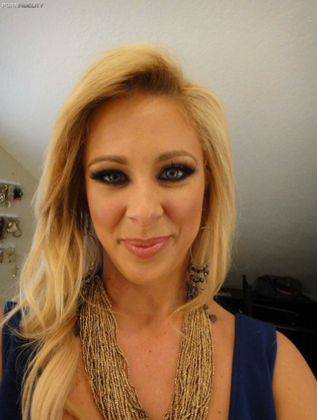 Curvy blonde pornstar Cherie Deville reveals her ass and fake tits